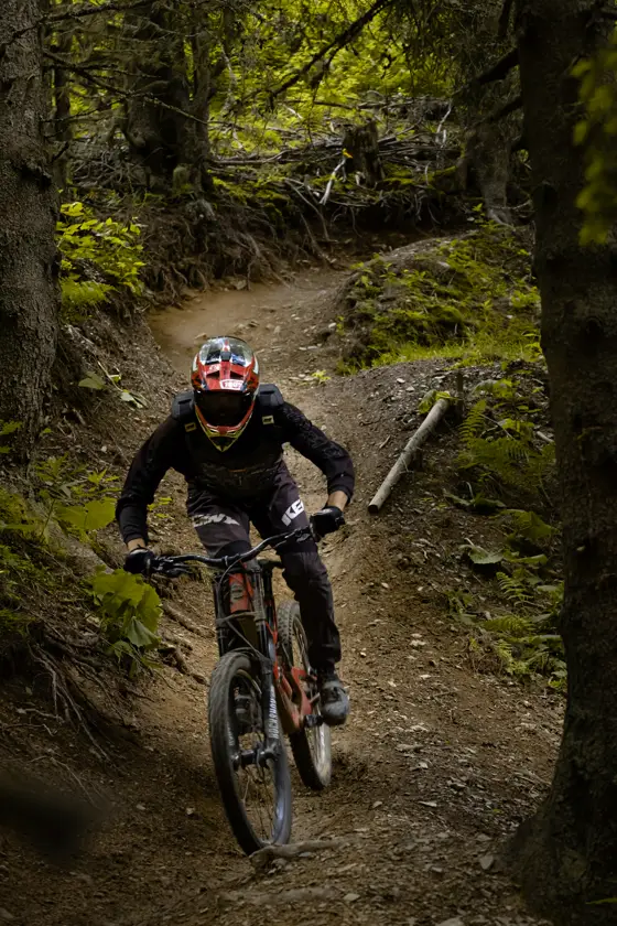 Ciclista con casco bajando por el sendero en una bicicleta de montaña